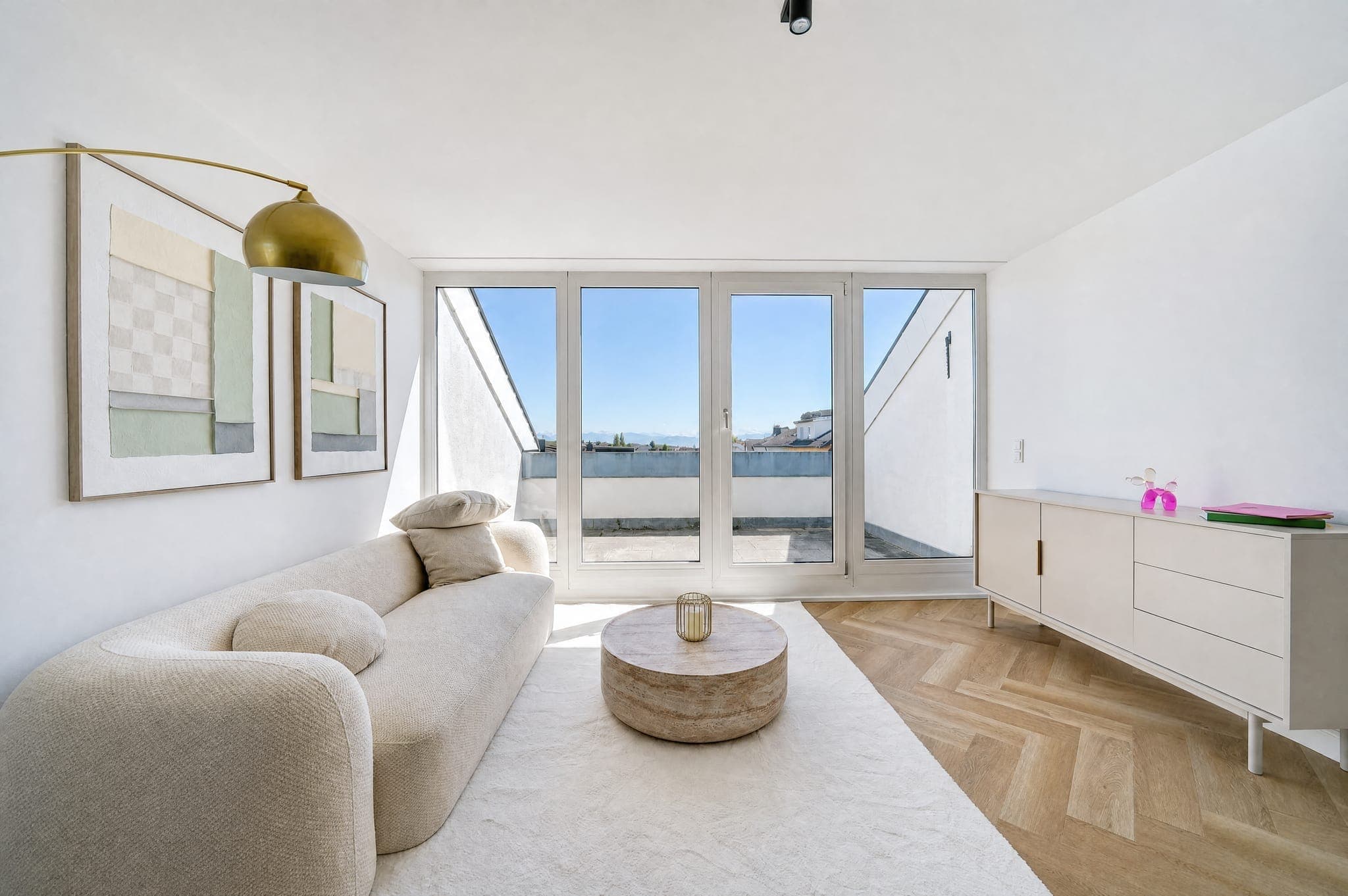 Wohnzimmer mit Rundsofa vor der Fensterfront zur Dachterrasse, blauer Himmel durchgezeichnet