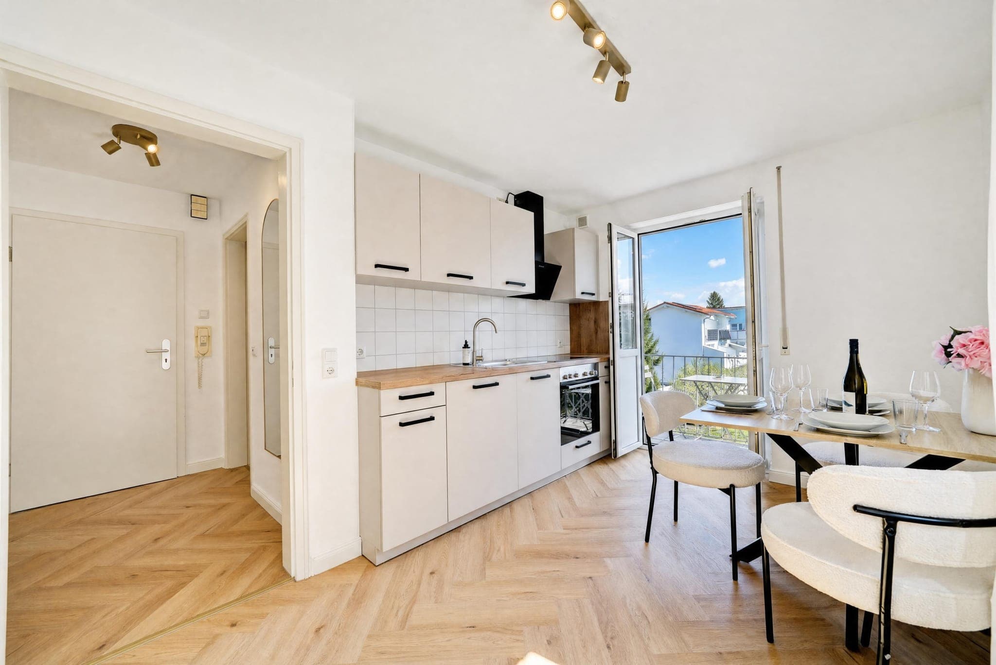 Küchenzeile mit gedecktem Esstisch am Balkonfenster
