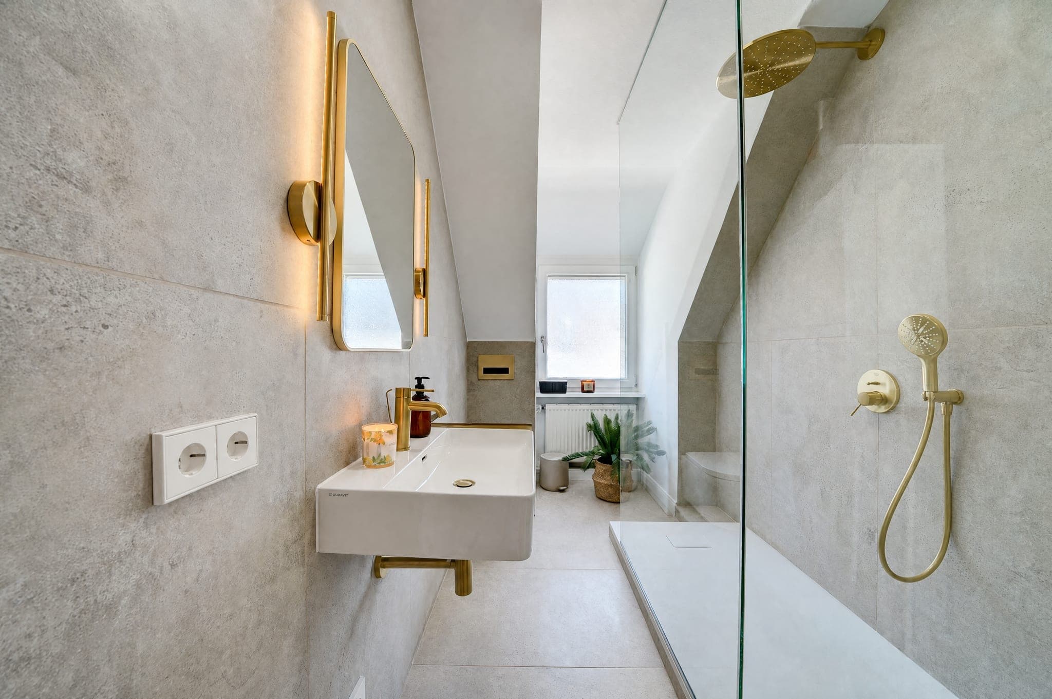 Badezimmer mit bodengleicher Dusche, Goldarmaturen und Aufsatzwaschbecken unter der Dachschräge